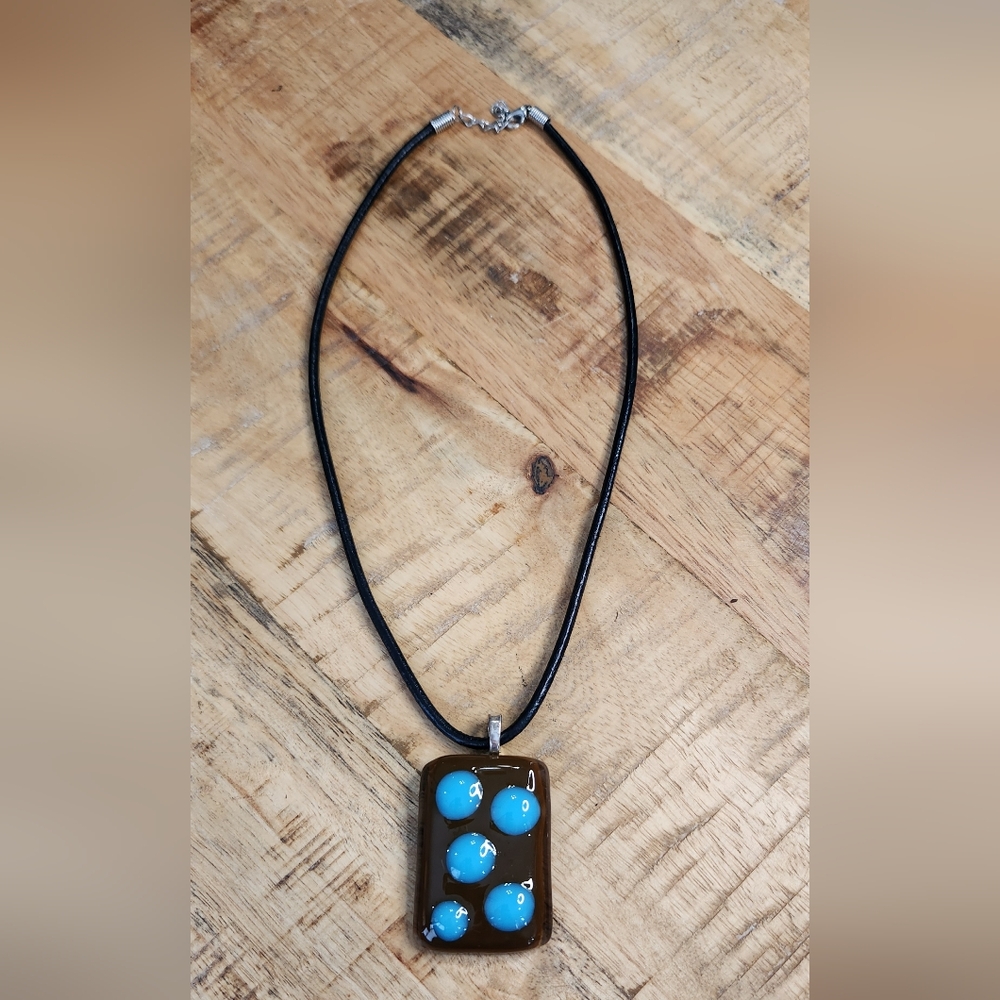 Leather necklace with brown and blue pendent.